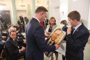 Prezydent ogląda swój portret namalowany przez młodzież.