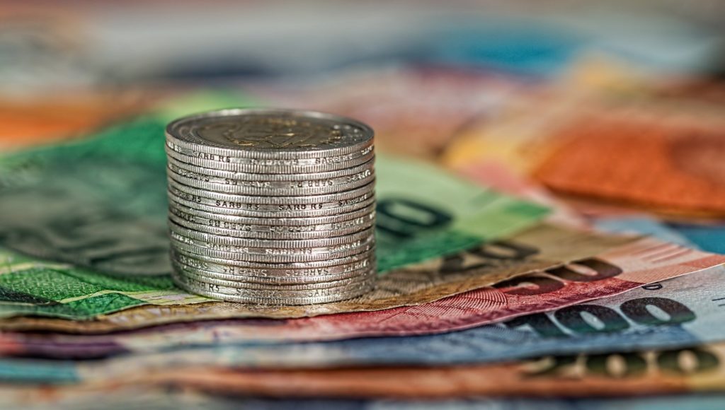 Zbliżenie - na banknotach w słupku ułożono monety