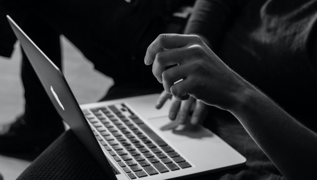 Osoba bierze udział w spotkaniu online. Ujęcie na ręce i laptop