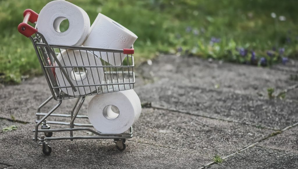 Koszyk sklepowy, zapełniony rolkami papieru toaletowego