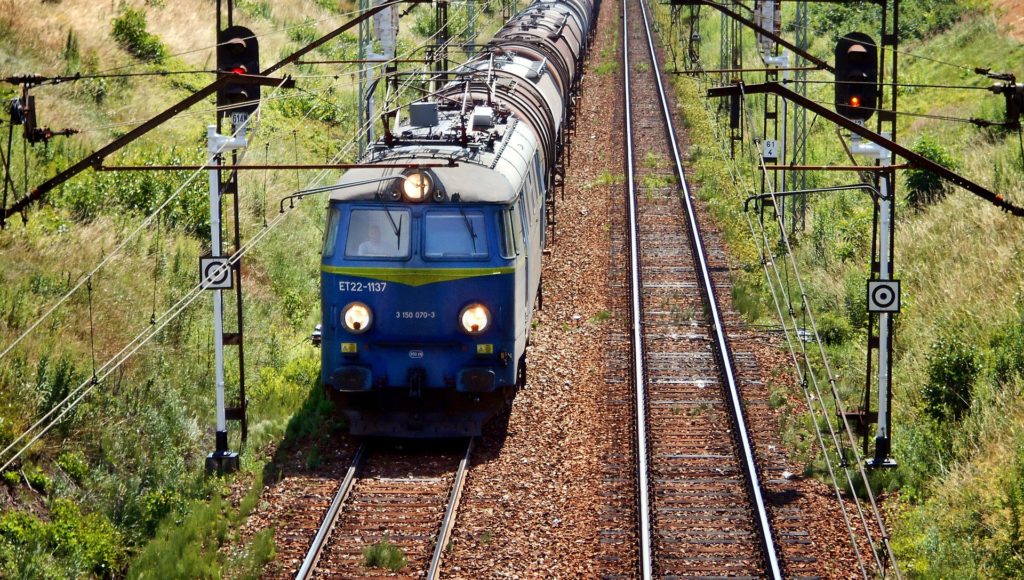 Pociąg jedzie po torach w słoneczny dzień