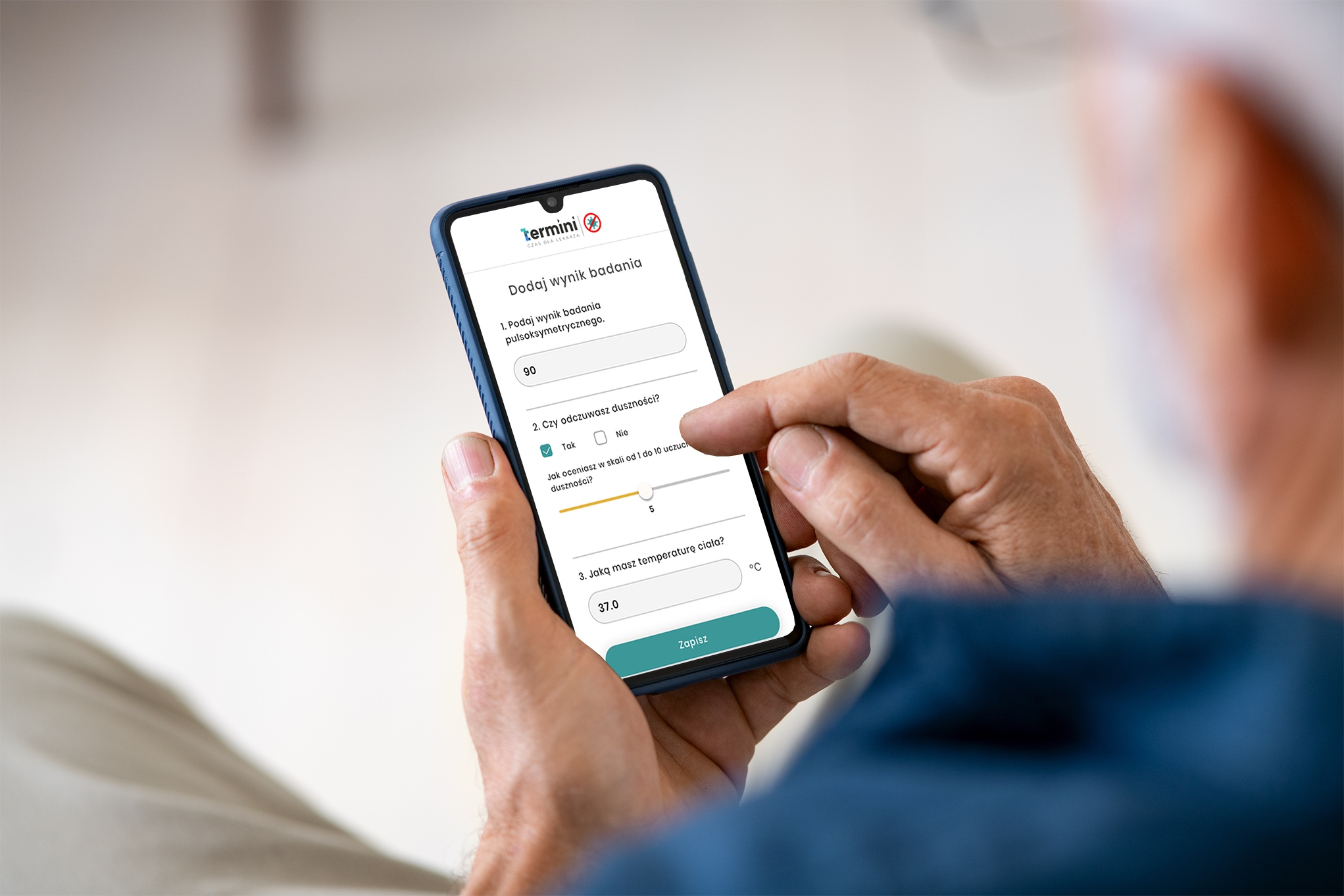 zbliżenie na ręce mężczyzny, który trzyma telefon z aplikacją COVID.Termini.app, widzimy go od tyłu