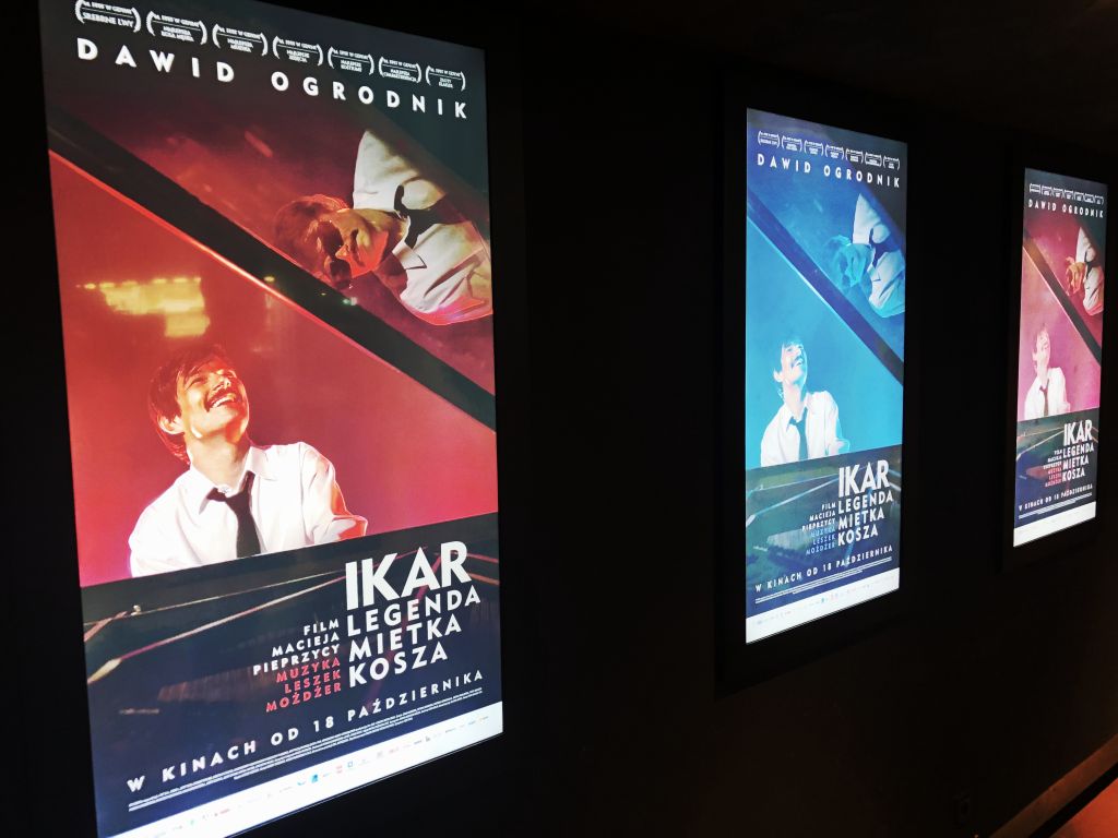 Na zdjęciu trzy plakaty dotyczące filmu, wiszą na ścianie w kinie