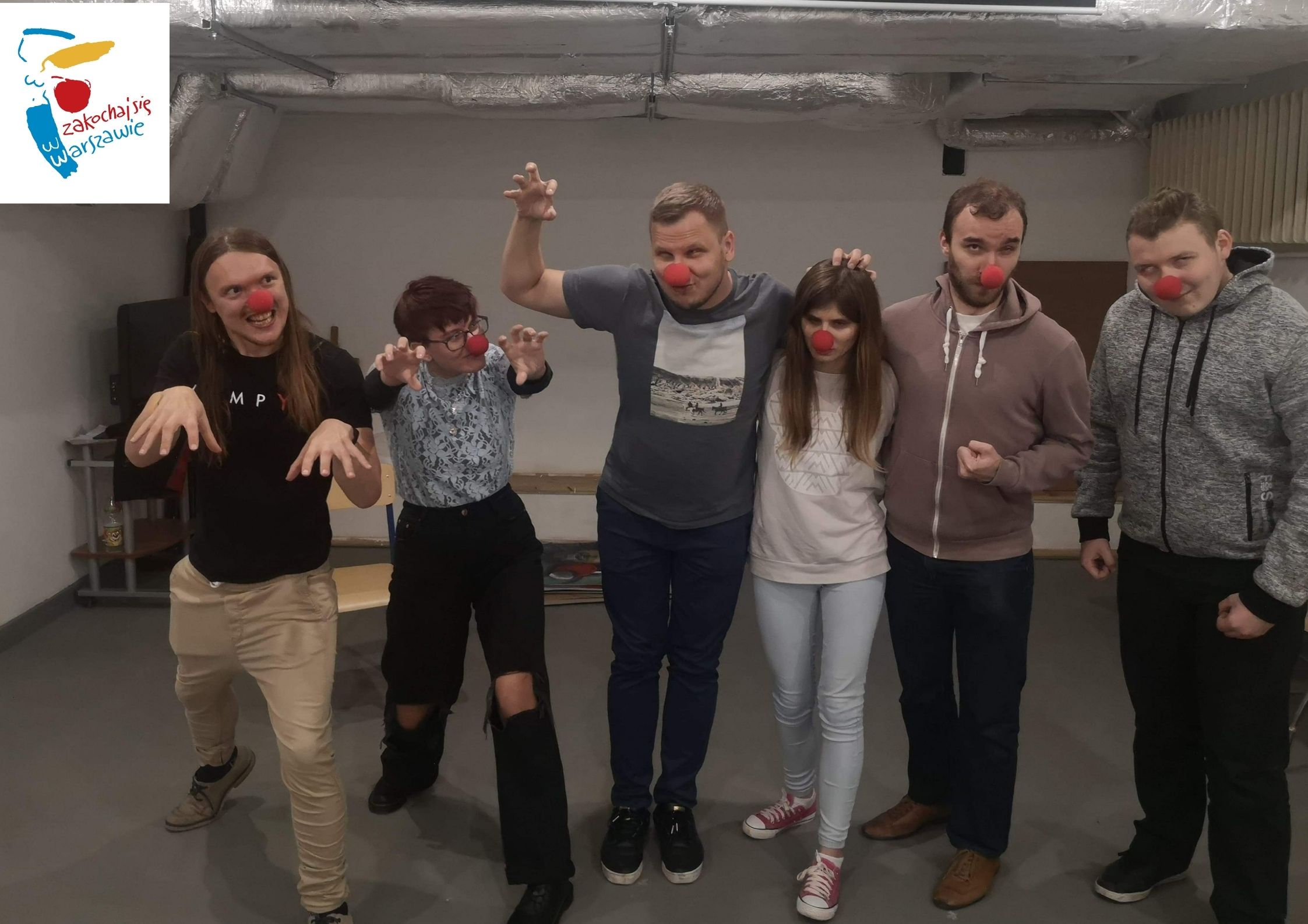 Sześciu aktorów Teatru Krzesiwo. Na nosach mają założone czerwone piłeczki. Troje z nich wyciąga przed siebie ręce.