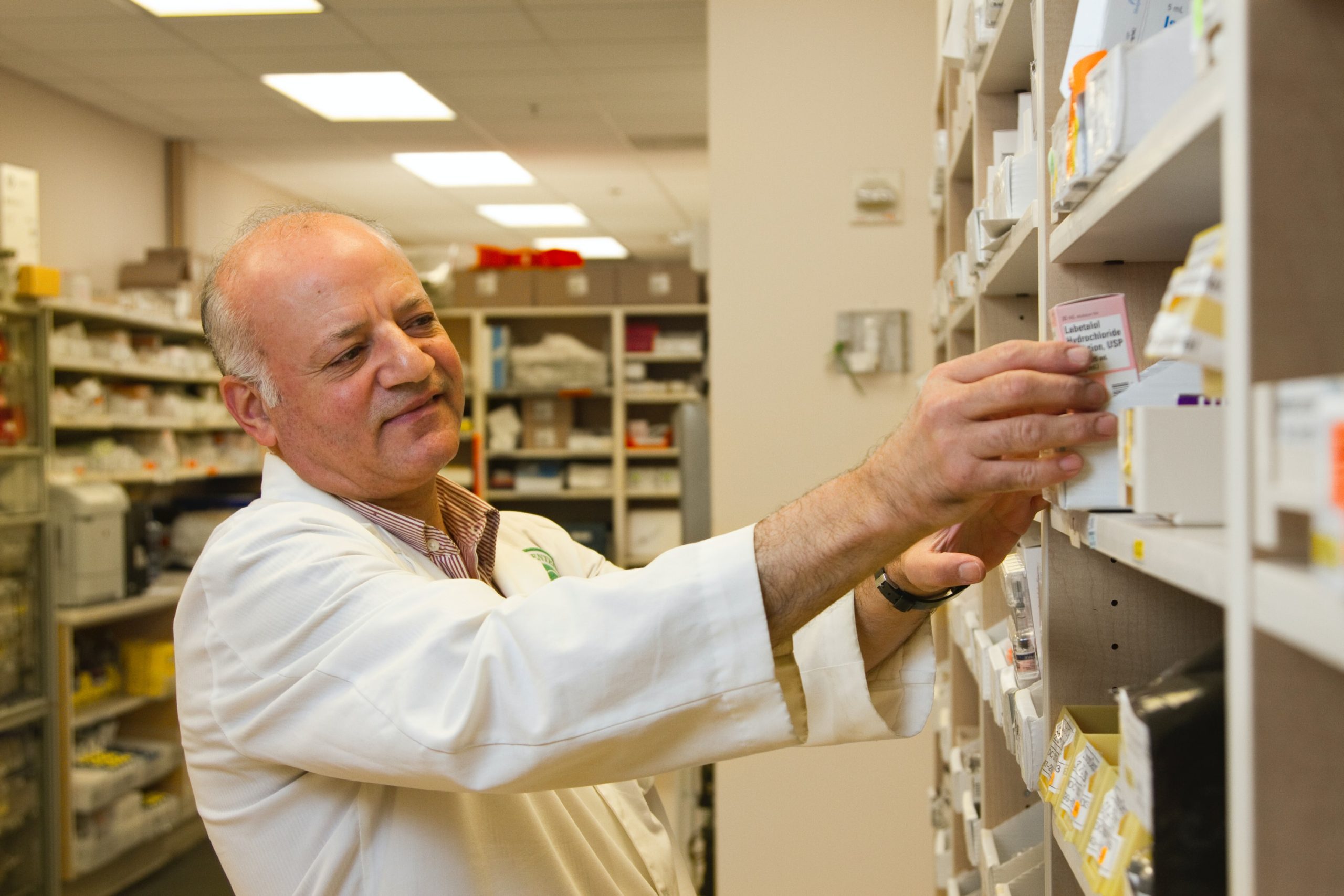 Farmaceuta bierze lek z półki w aptece