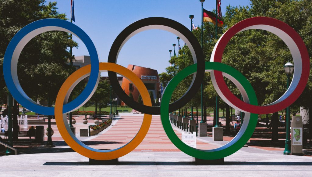 Koła olimpijskie w tle budynek