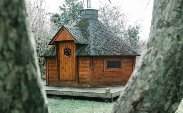 Drewniany, zabytkowy domek wśród drzew