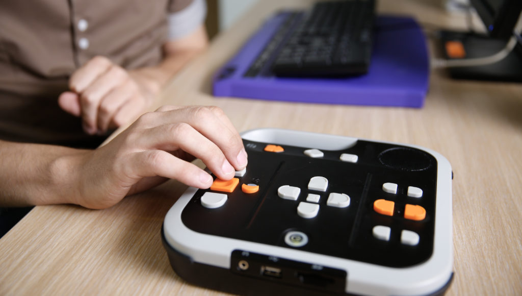 Dłoń na klawiaturze sprzętu dla osób niewidomych