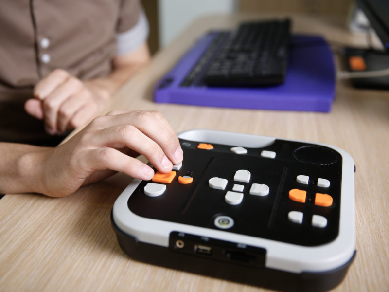 Dłoń na klawiaturze sprzętu dla osób niewidomych