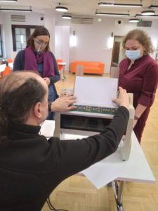 Uczestnicy oberwują prowadzącego warsztaty, który obsługuje drukarkę brajlowską