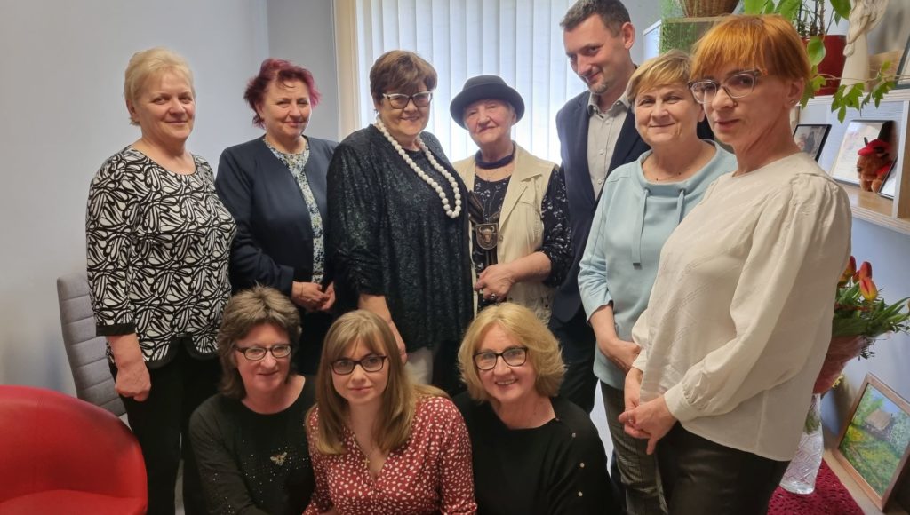 członkowie koła PZN w Zambrowie i delegacji z Warszawy stoją razem, uśmiechają się do zdjęcia