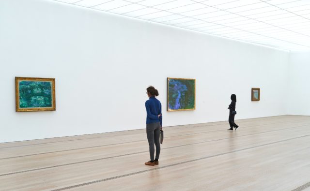 Sala wystaw, a tam dwie kobiety oglądają obrazy