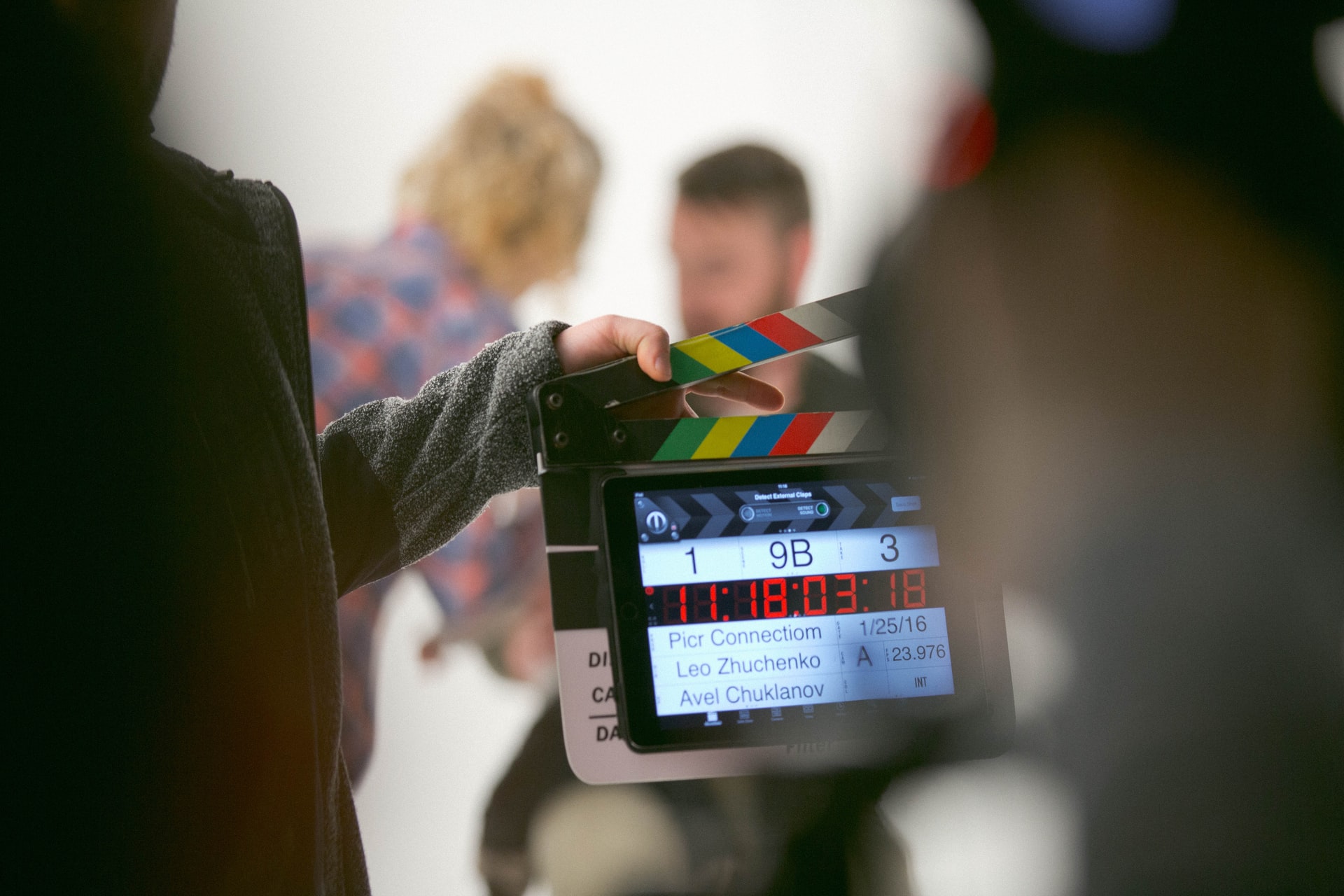 Dwie młode osoby na planie filmowym, tło rozmyte, na środku klaps.