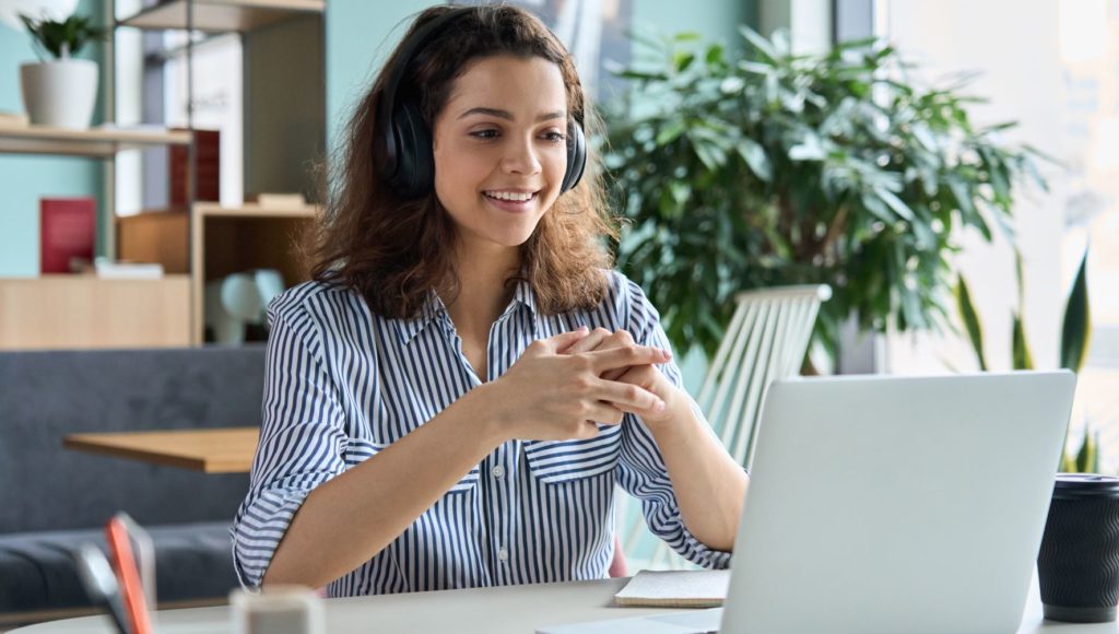 Dziewczyna siedzi w domu przed laptopem i ma spotkanie online