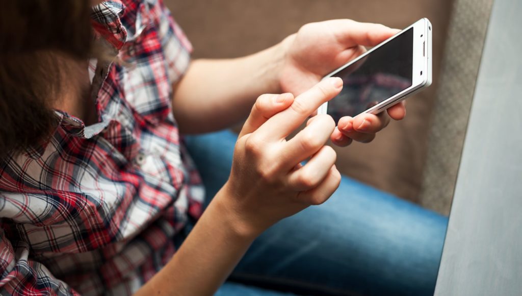 Kobieta trzyma telefon komórkowy w dłoni