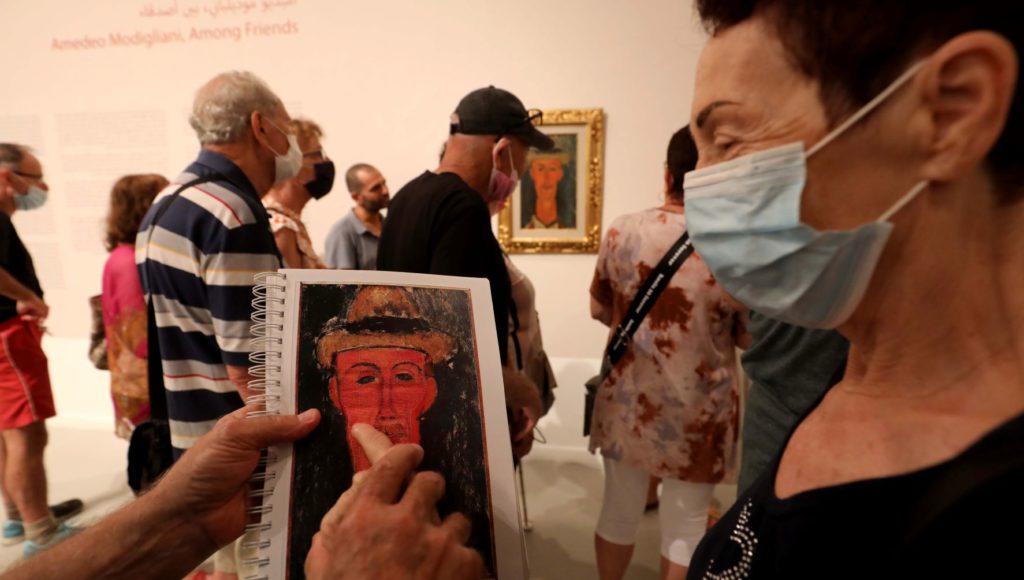 Muzeum, niewidoma kobieta dotyka tyflografiki obrazu