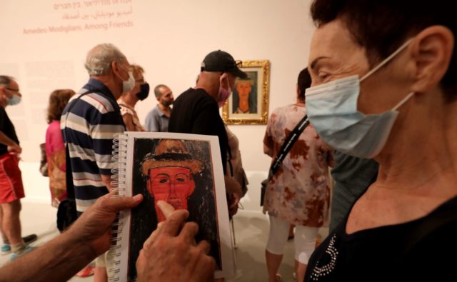 Muzeum, niewidoma kobieta dotyka tyflografiki obrazu
