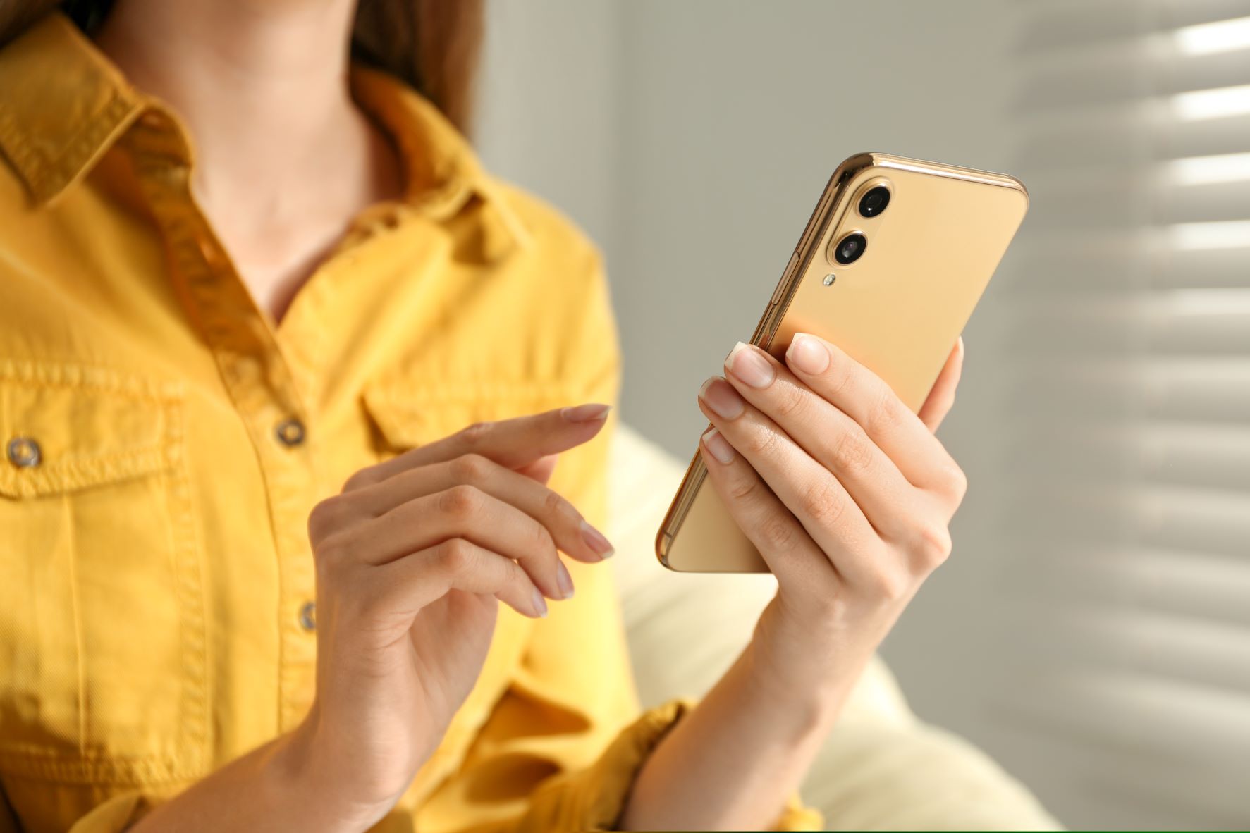 Kobieta trzyma w dłoni smartphone.