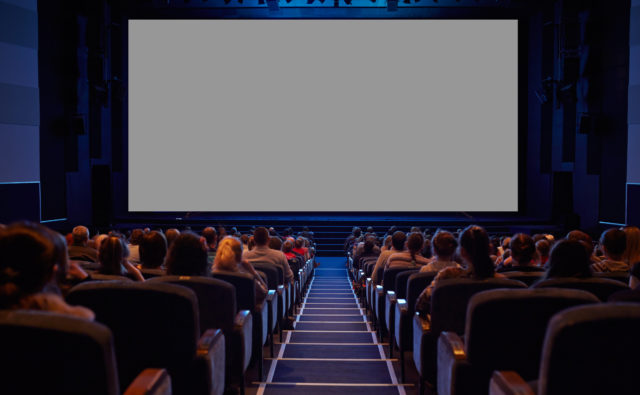 Widzowie w kinie czekają na emisję filmu