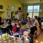 widok na salę w siedzibie koła, przy stolikach siedzą zaproszeni goście, na stołach ozdoby świąteczne i jedzenie