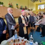 biskup mówi do mikrofonu i święci pokarmy