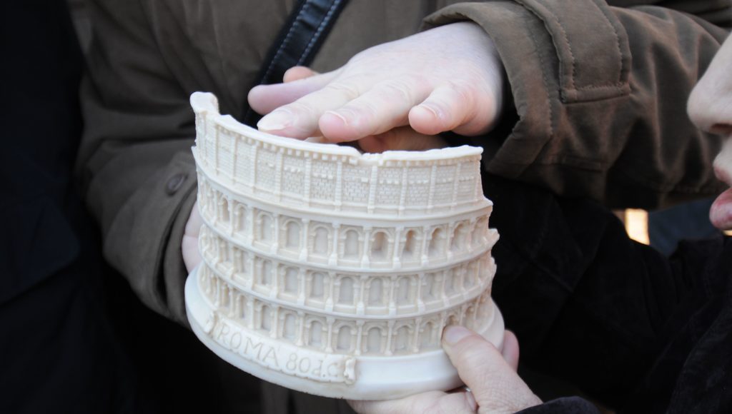 Makieta zabytku wydrukowana na drukarce 3D. Ktoś dłonią dotyka tej makiety.