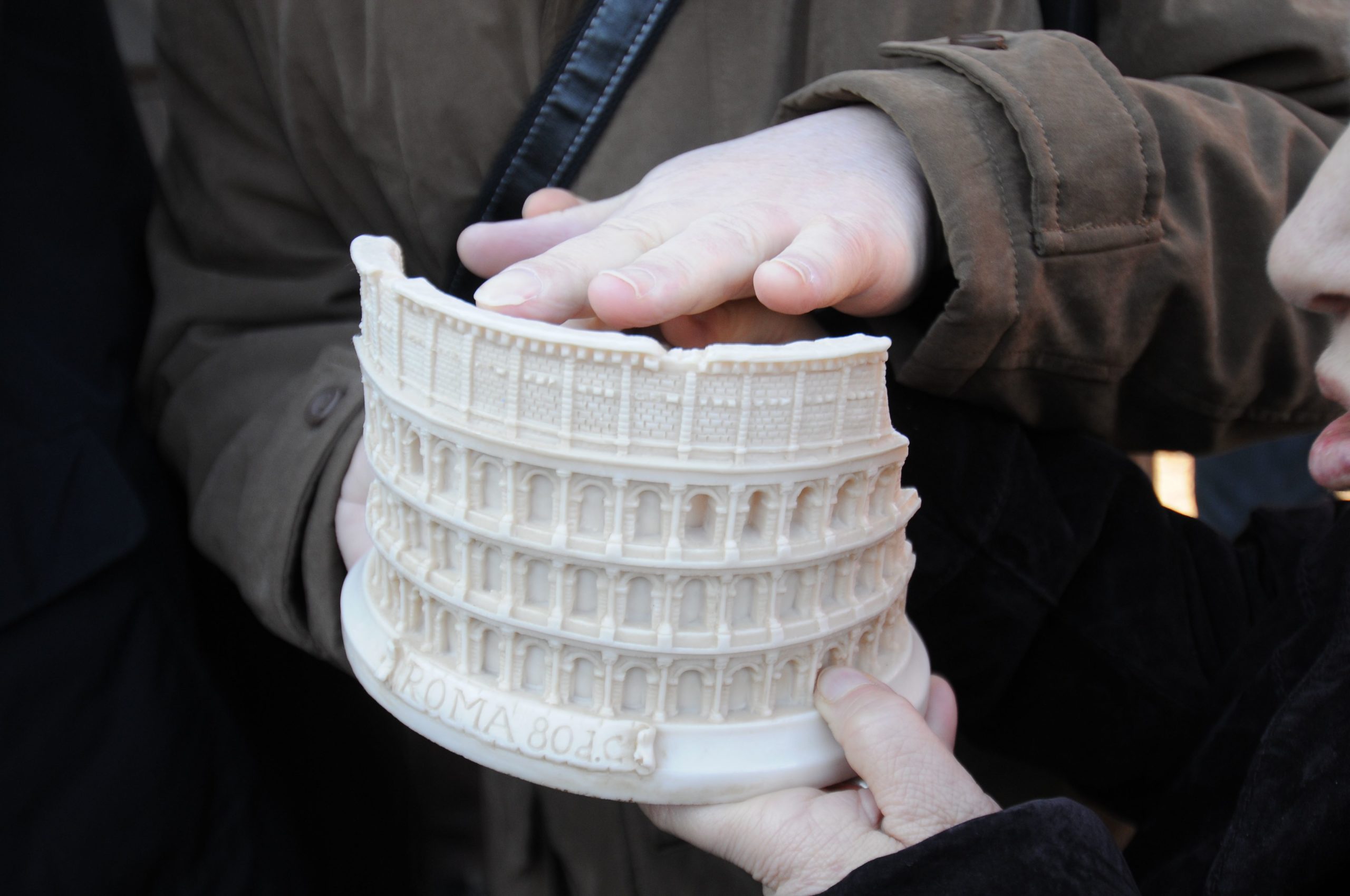 Makieta zabytku wydrukowana na drukarce 3D. Ktoś dłonią dotyka tej makiety.