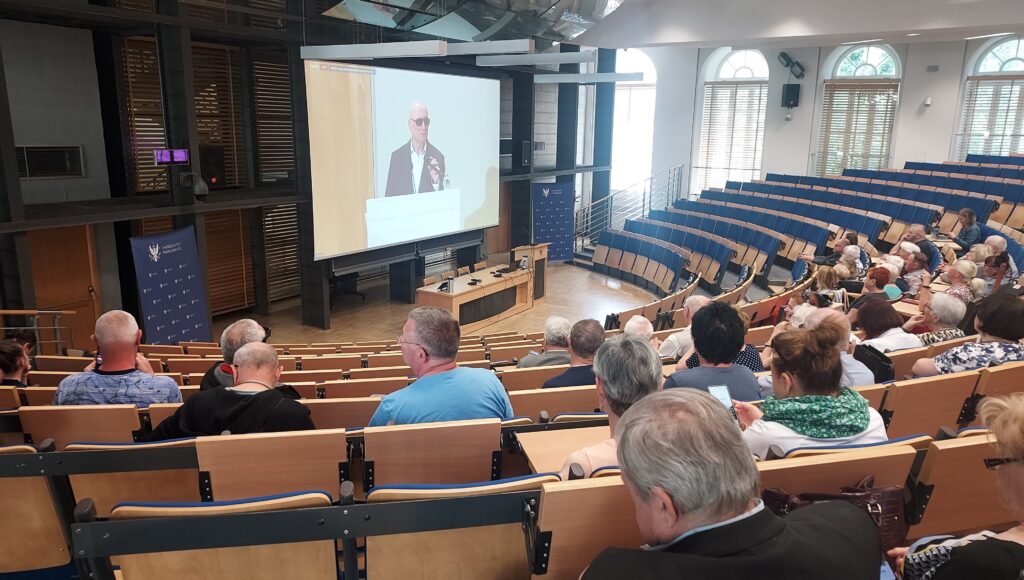 Transmisja przemówienia Marka Kalbarczyka w auli konferencyjnej UW