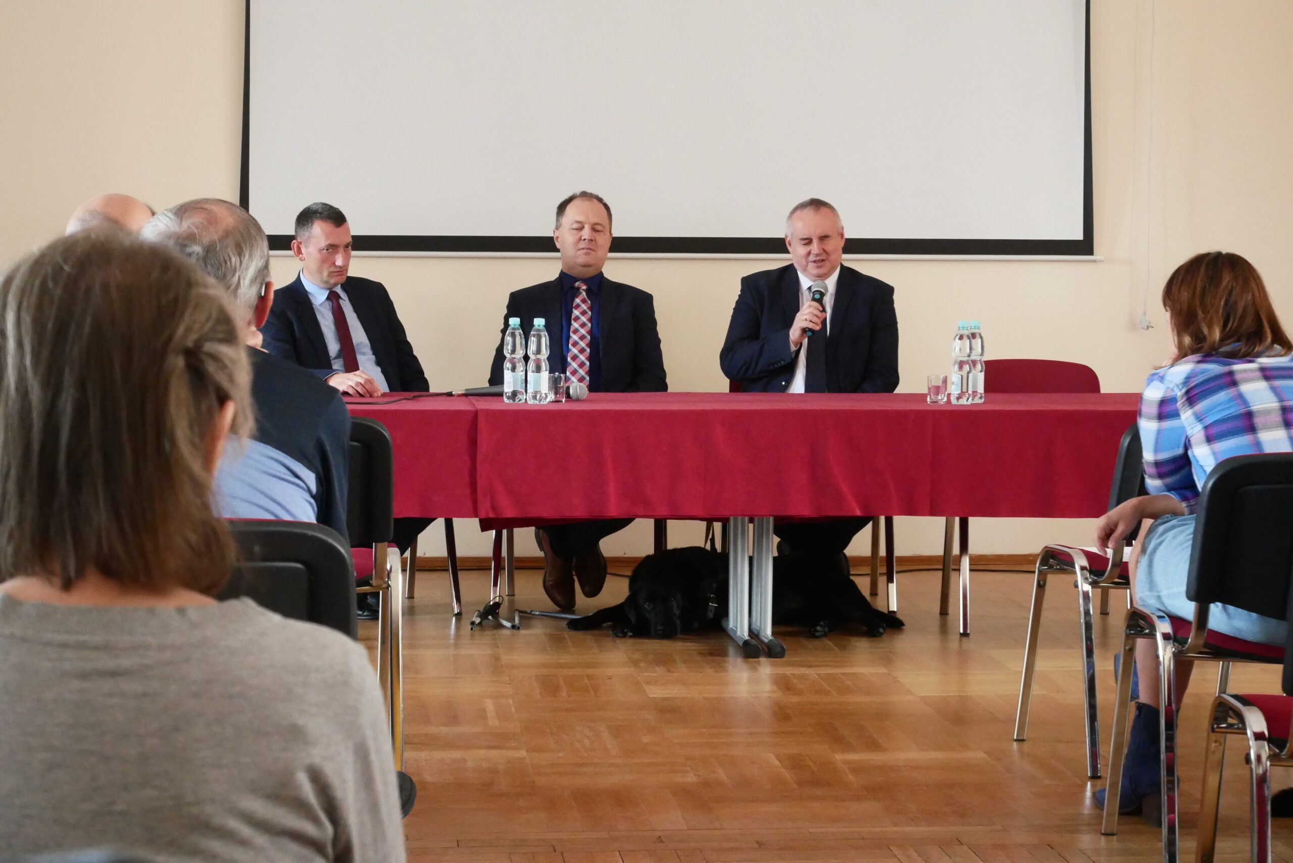 Na spotkaniu za stołem prezydialnym Paweł Wdówik, Andrzej Brzeziński, Krzysztof Teśniarz.