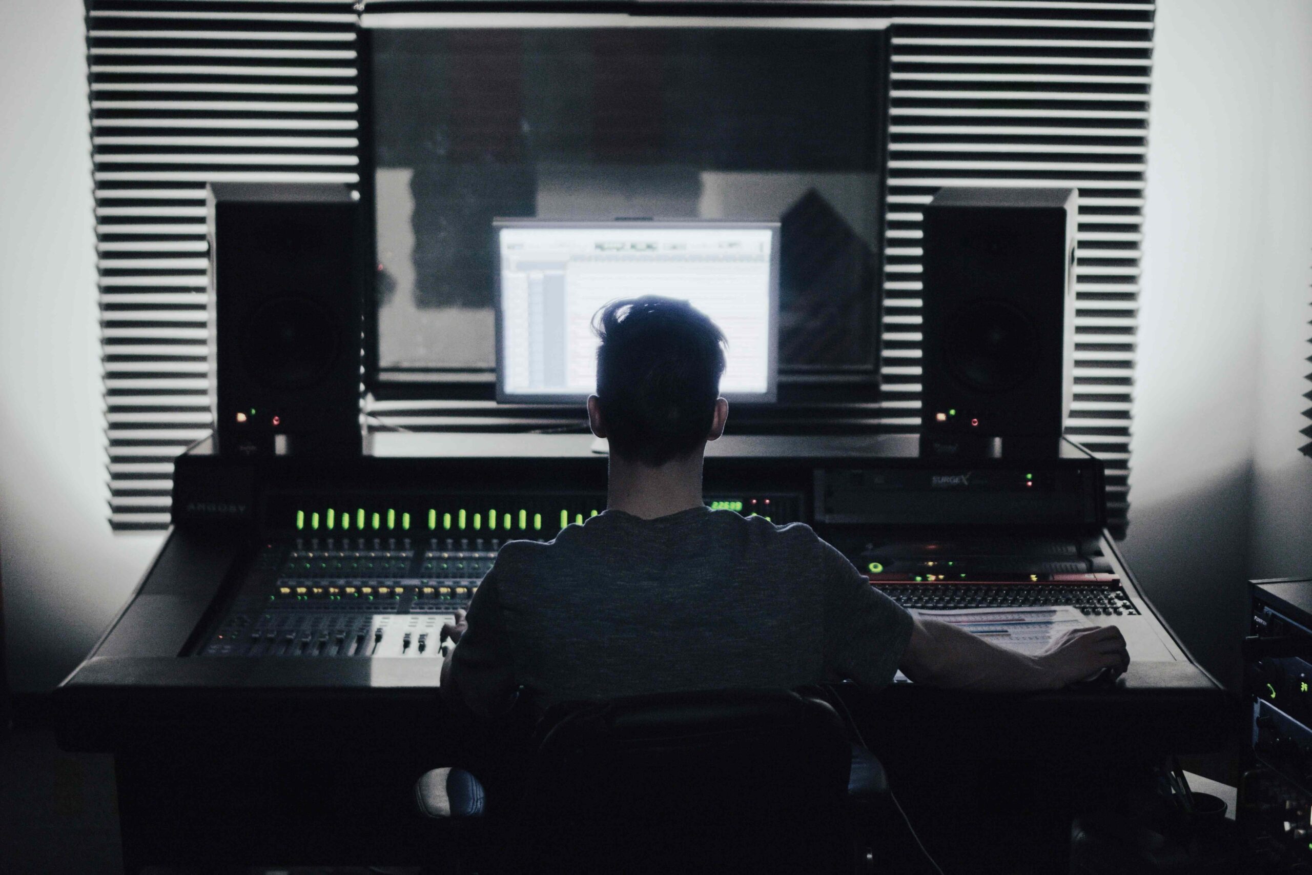 Mężczyzna w studio radiowym nagrywa audycję.