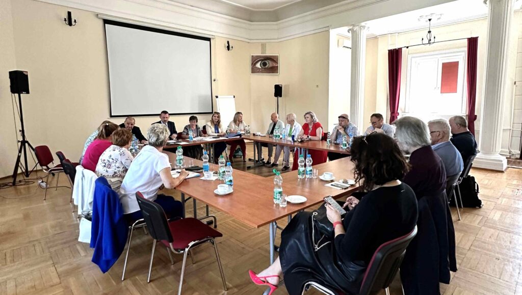 Przedstawiciele Zarządu Głównego PZN siedzą przy stole w trakcie obrad.
