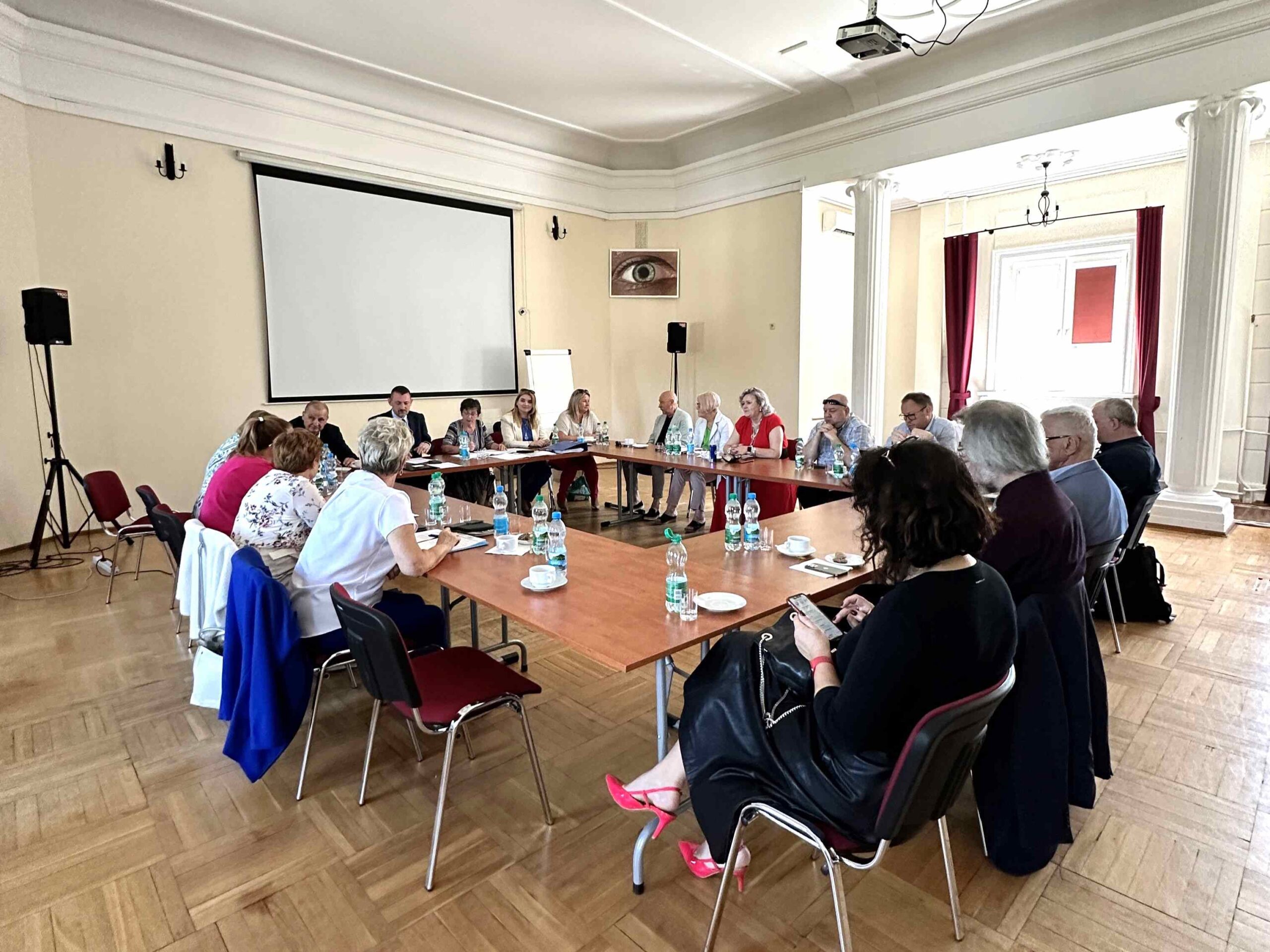 Przedstawiciele Zarządu Głównego PZN siedzą przy stole w trakcie obrad.