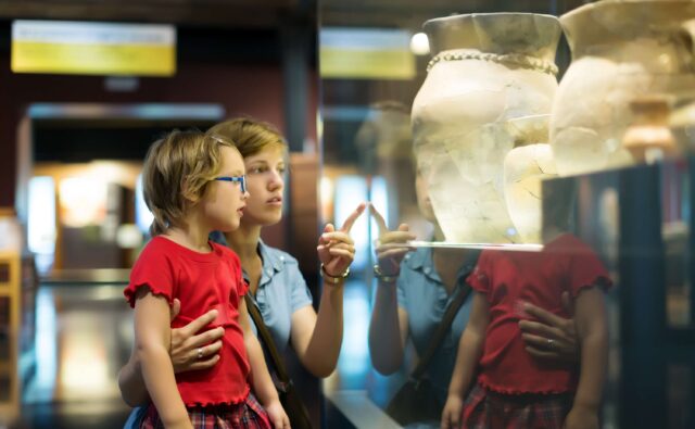 Dzieci oglądają eksponaty w muzeum.