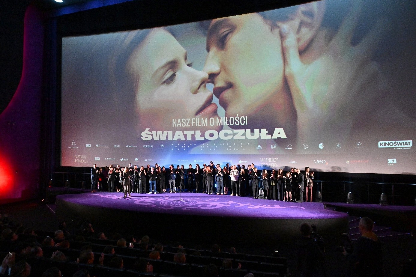 Na scenie wszystkie osoby, które brały udział w tworzeniu filmu. Zdjęcie z premiery, U góry ujęcie z filmu.