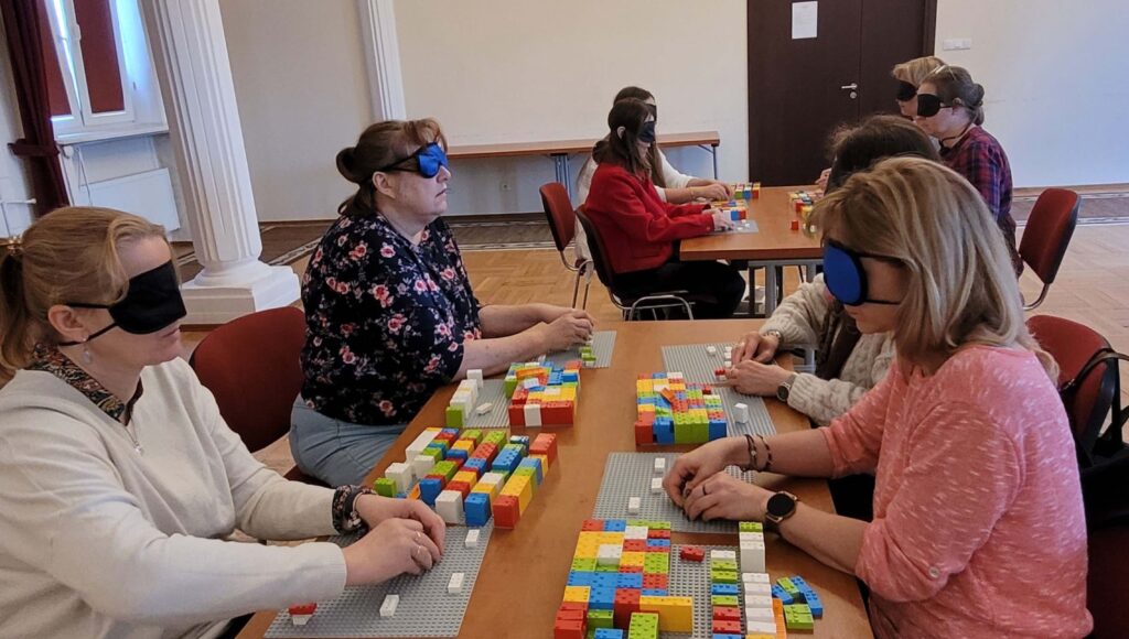 Uczestnicy szkolenia LEGO BRAILLE BRICKS w trakcie układania klocków i ćwiczenia nowych umiejętności.
