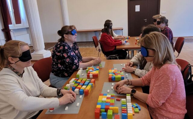 Uczestnicy szkolenia LEGO BRAILLE BRICKS w trakcie układania klocków i ćwiczenia nowych umiejętności.