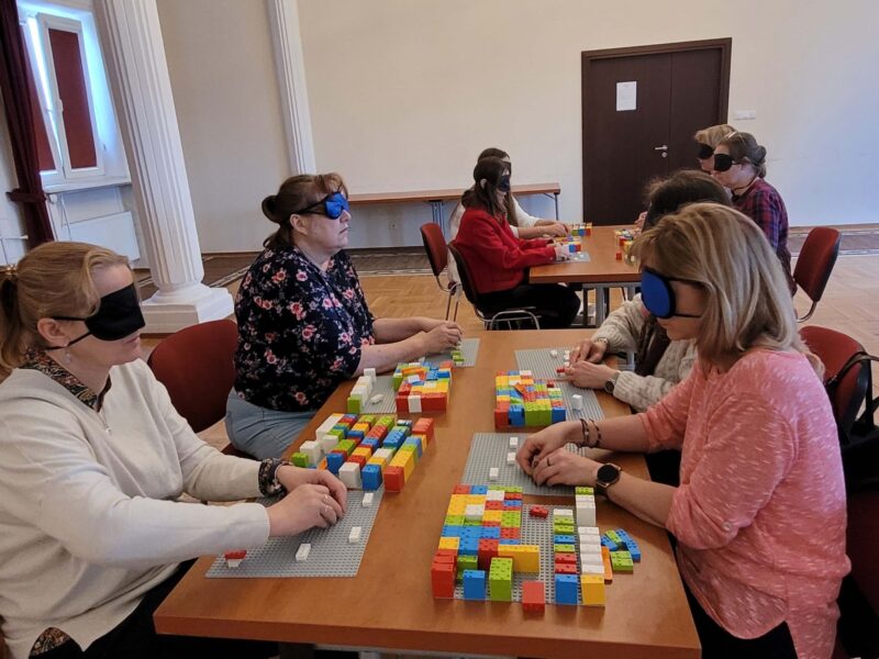 Uczestnicy szkolenia LEGO BRAILLE BRICKS w trakcie układania klocków i ćwiczenia nowych umiejętności.