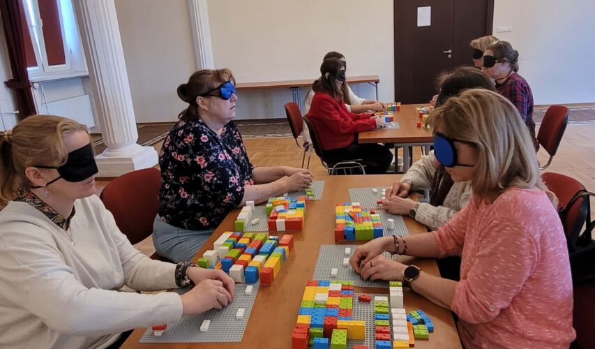 Uczestnicy szkolenia LEGO BRAILLE BRICKS w trakcie układania klocków i ćwiczenia nowych umiejętności.