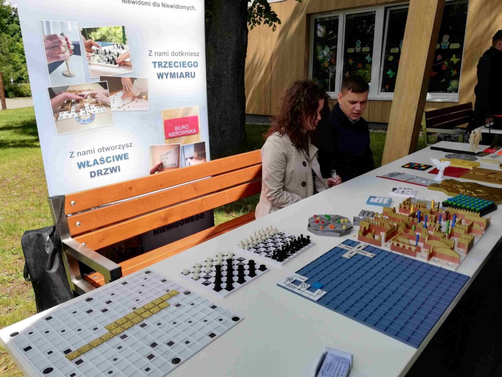 Stoisko Fundacji Prowadnica z robionymi przez nich grami dla osób niewidomych. Rozstawione scrabble, chińczyk, szachy i inne.