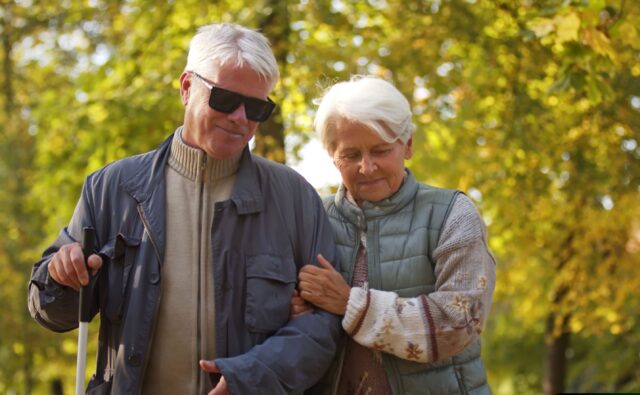 Para seniorów spaceruje parkiem.