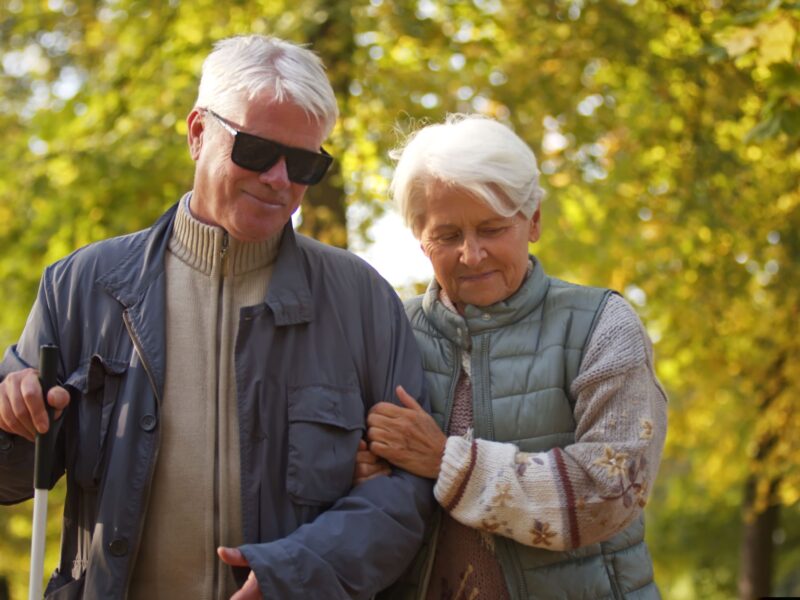 Para seniorów spaceruje parkiem.