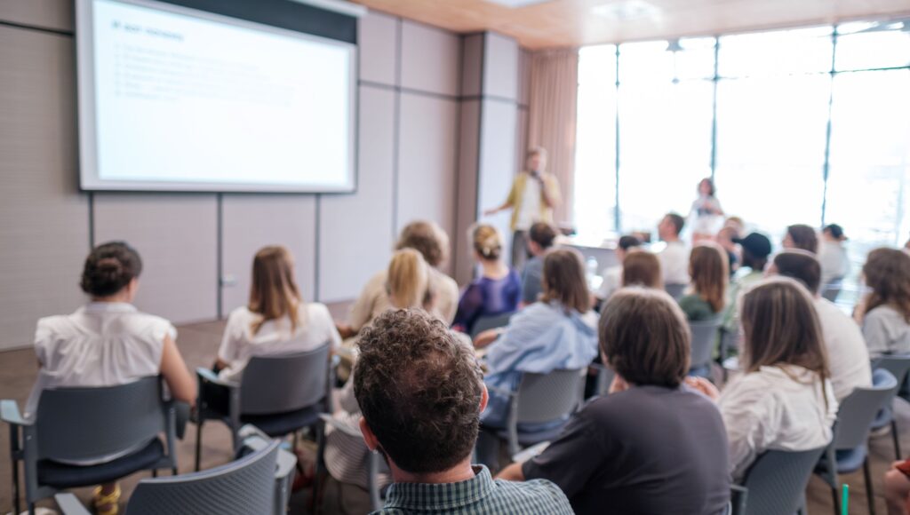 Prelegent zabiera głos w trakcie spotkania na konferencji.