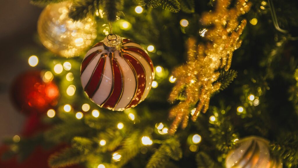 Kolorowa bombka zawieszona na gałązce choinki.