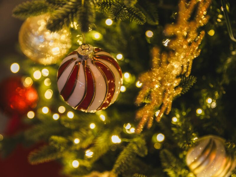 Kolorowa bombka zawieszona na gałązce choinki.