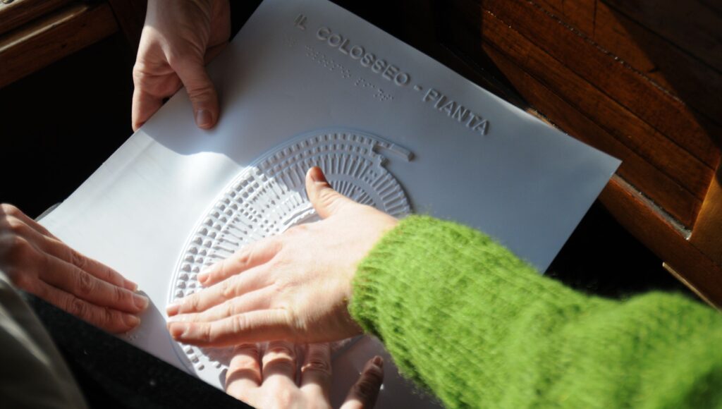 Na zdjęciu palce przesuwają się po tyflografice.