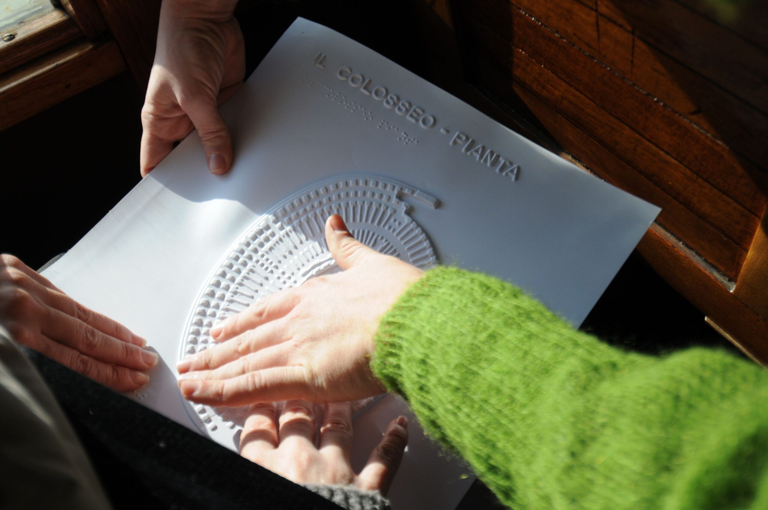 Na zdjęciu palce przesuwają się po tyflografice.