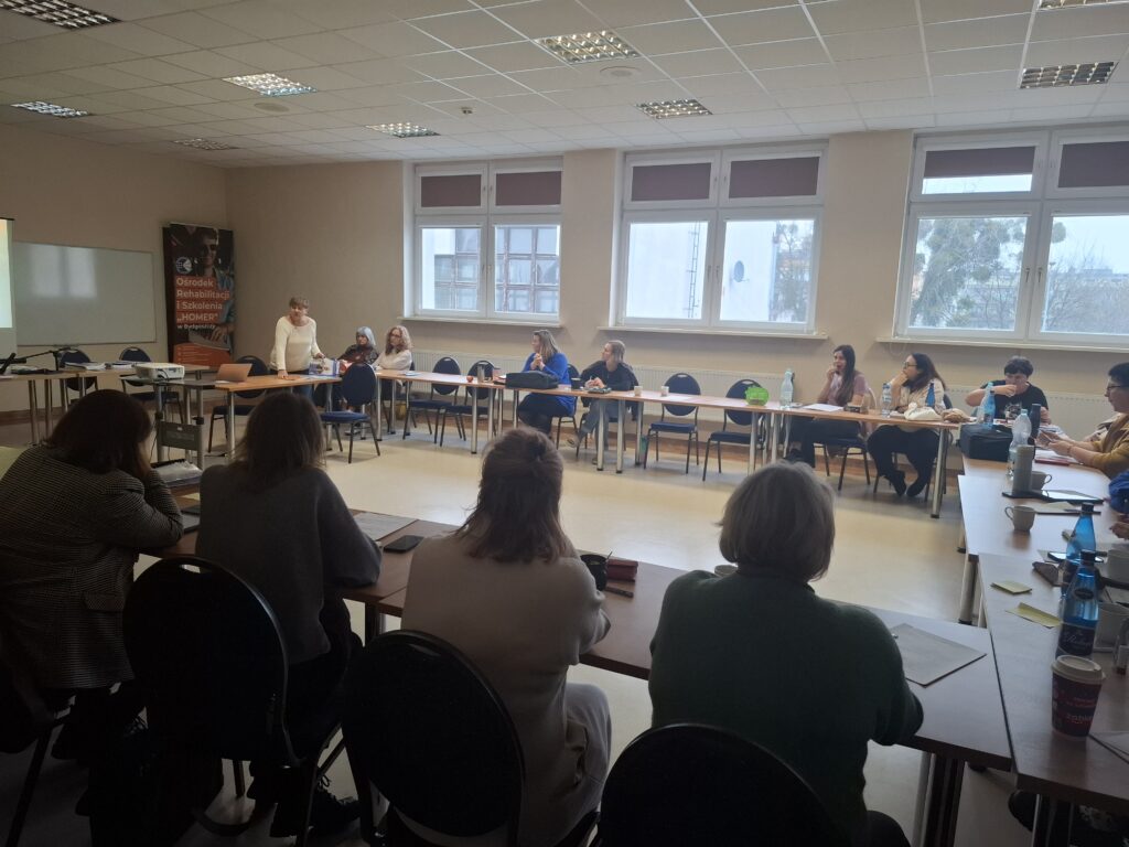 Uczestnicy szkolenia z programów rehabilitacyjnych słuchają wykładu trenera.