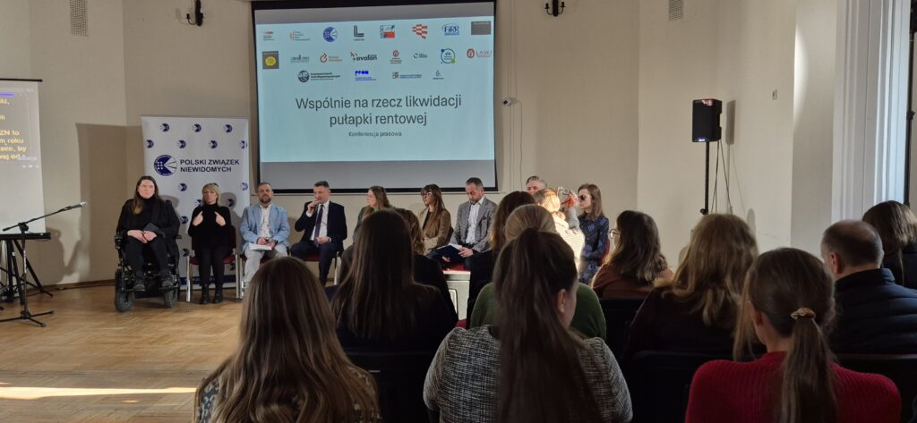 Uczestnicy słuchają konferencji prasowej w sprawie likwidacji pułapki rentowej.