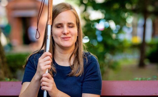 Na zdjęciu: niewidoma kobieta na ławce w parku.