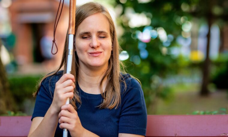 Na zdjęciu: niewidoma kobieta na ławce w parku.